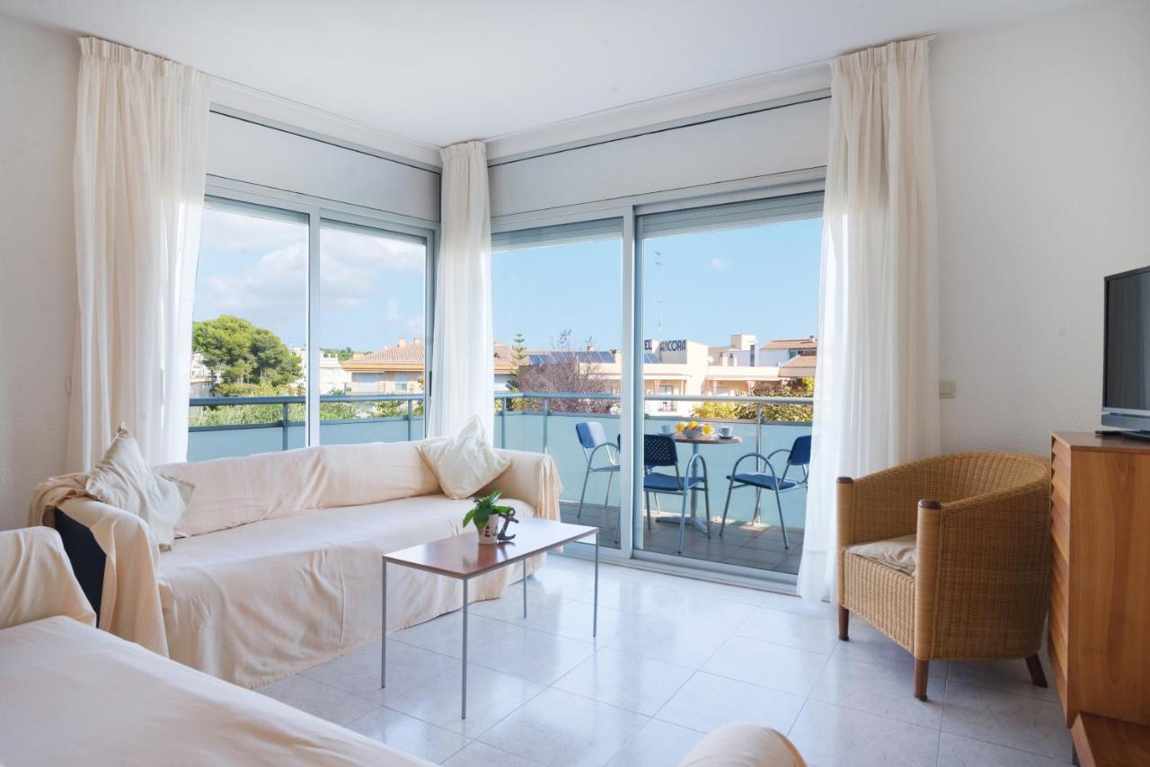 een woonkamer met een bank en een groot raam bij Apartaments Ancora in Palamós