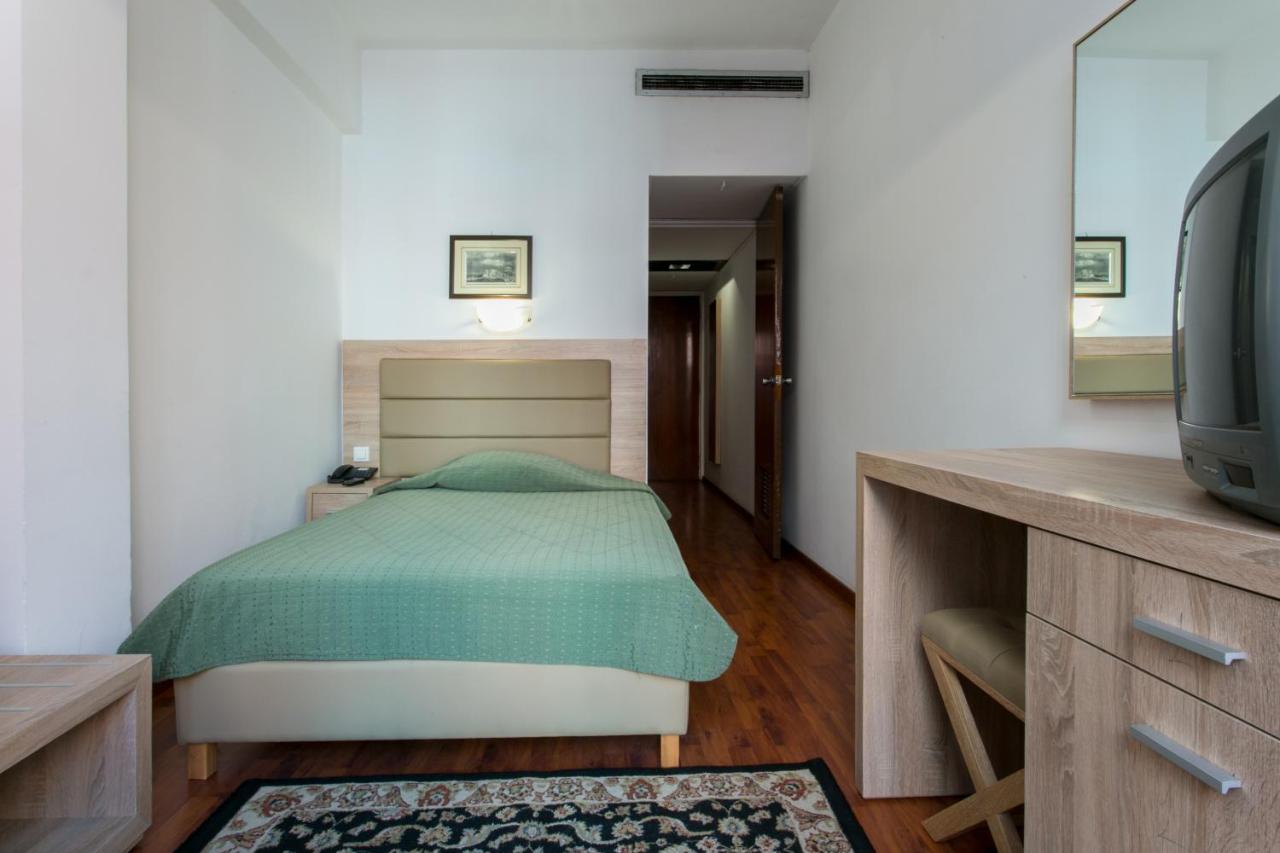 een slaapkamer met een bed en een tv erin bij Arethusa Hotel Athens in Athene