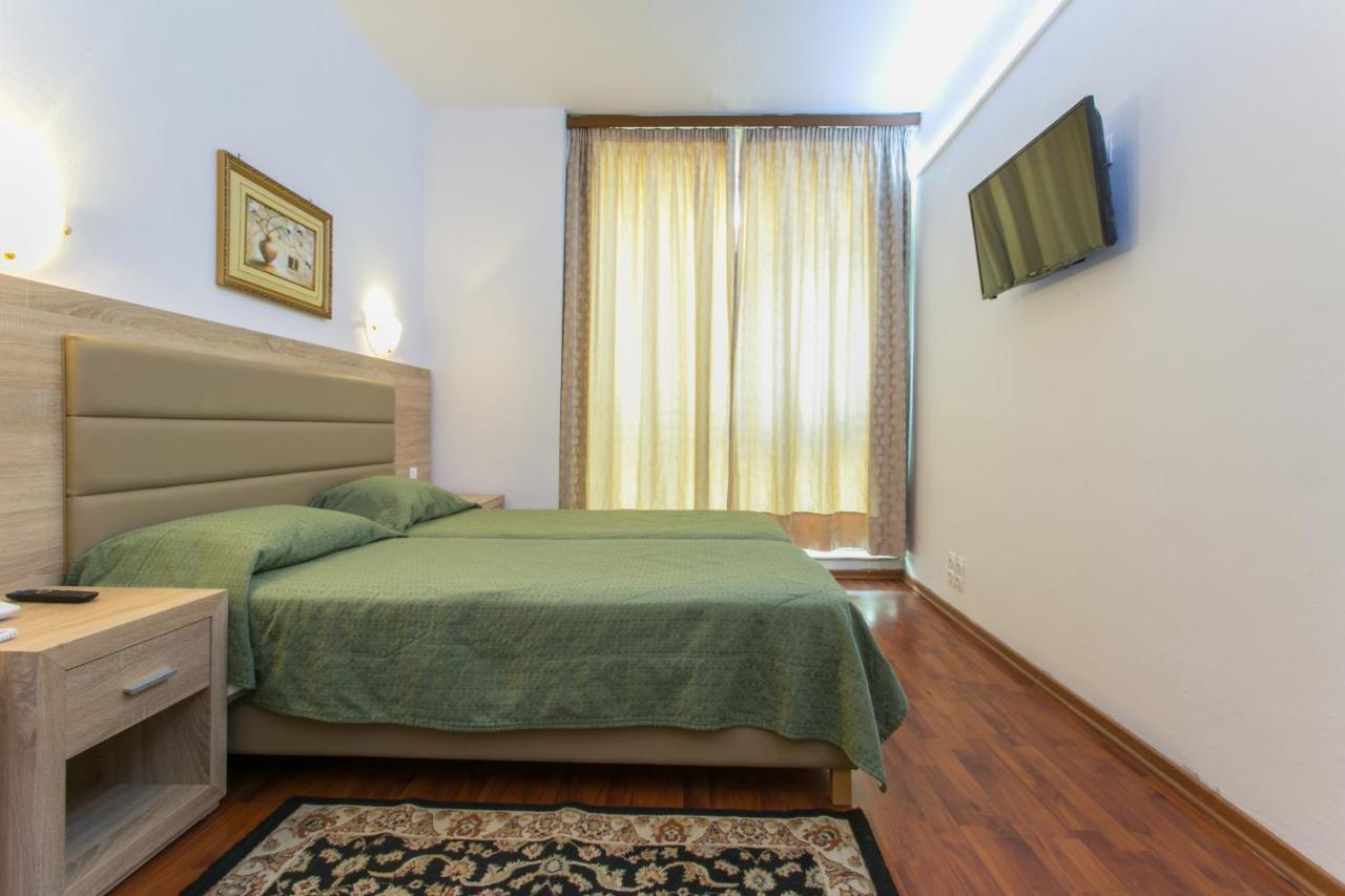 een slaapkamer met een groen bed en een raam bij Arethusa Hotel Athens in Athene