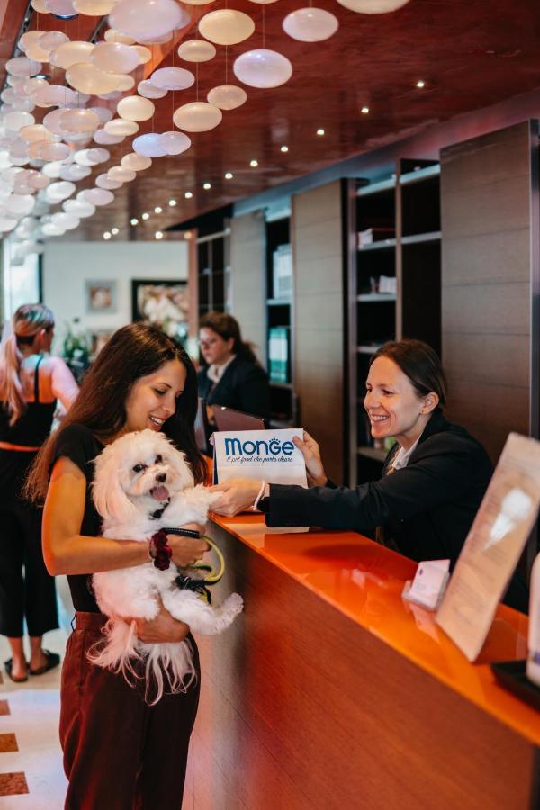 Een vrouw met een hond bij de toonbank van een winkel. bij Hotel Adlon in Lido di Jesolo
