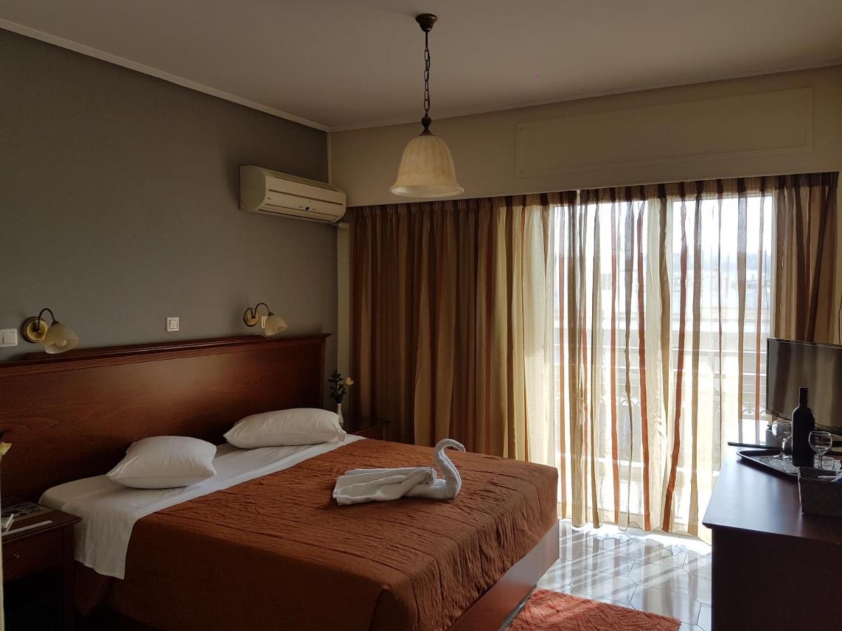 een hotelkamer met een bed en een groot raam bij Apollo Hotel in Athene