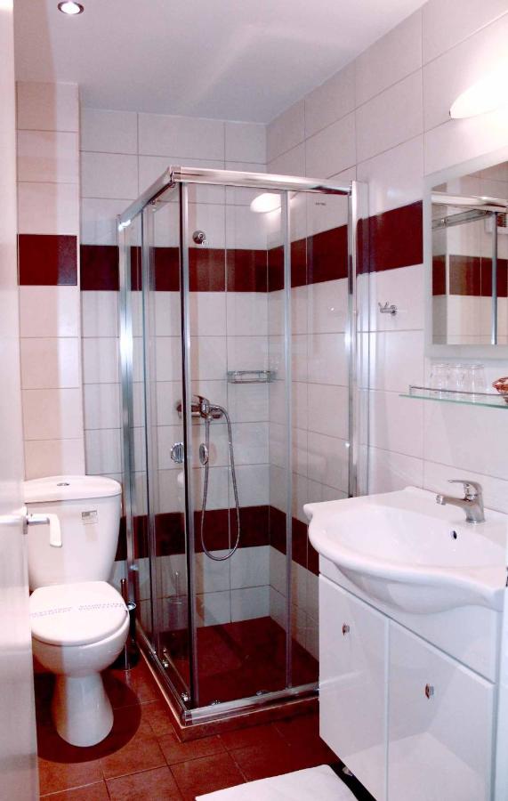 een badkamer met een douche, een toilet en een wastafel bij Apollo Hotel in Athene