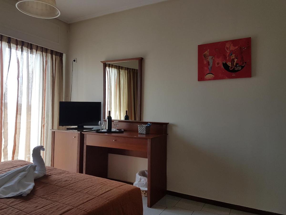 een slaapkamer met een bureau met een computer en een spiegel bij Apollo Hotel in Athene