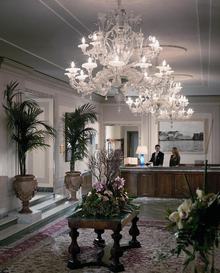 een hotellobby met een kroonluchter en een man bij Grand Hotel Vesuvio in Napels +58 foto's