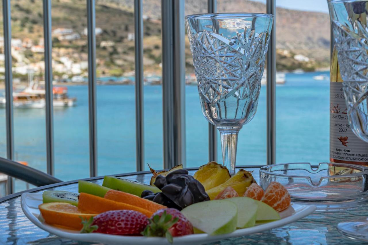 Een fruitschaal op tafel met een wijnglas ernaast. bij Aristea Hotel in Elounda