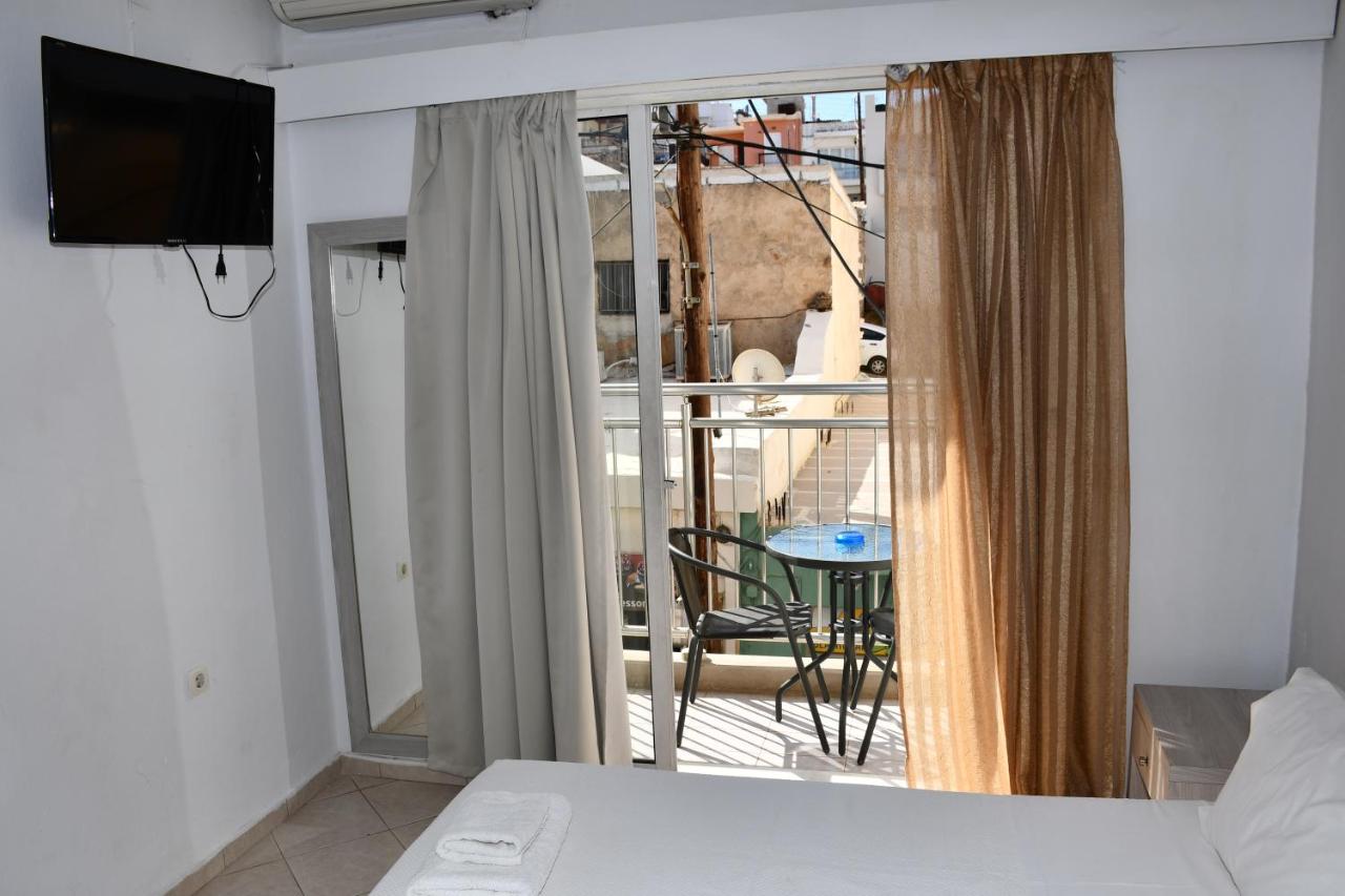 een slaapkamer met een bed en een balkon met een tafel bij Aristea Hotel in Elounda