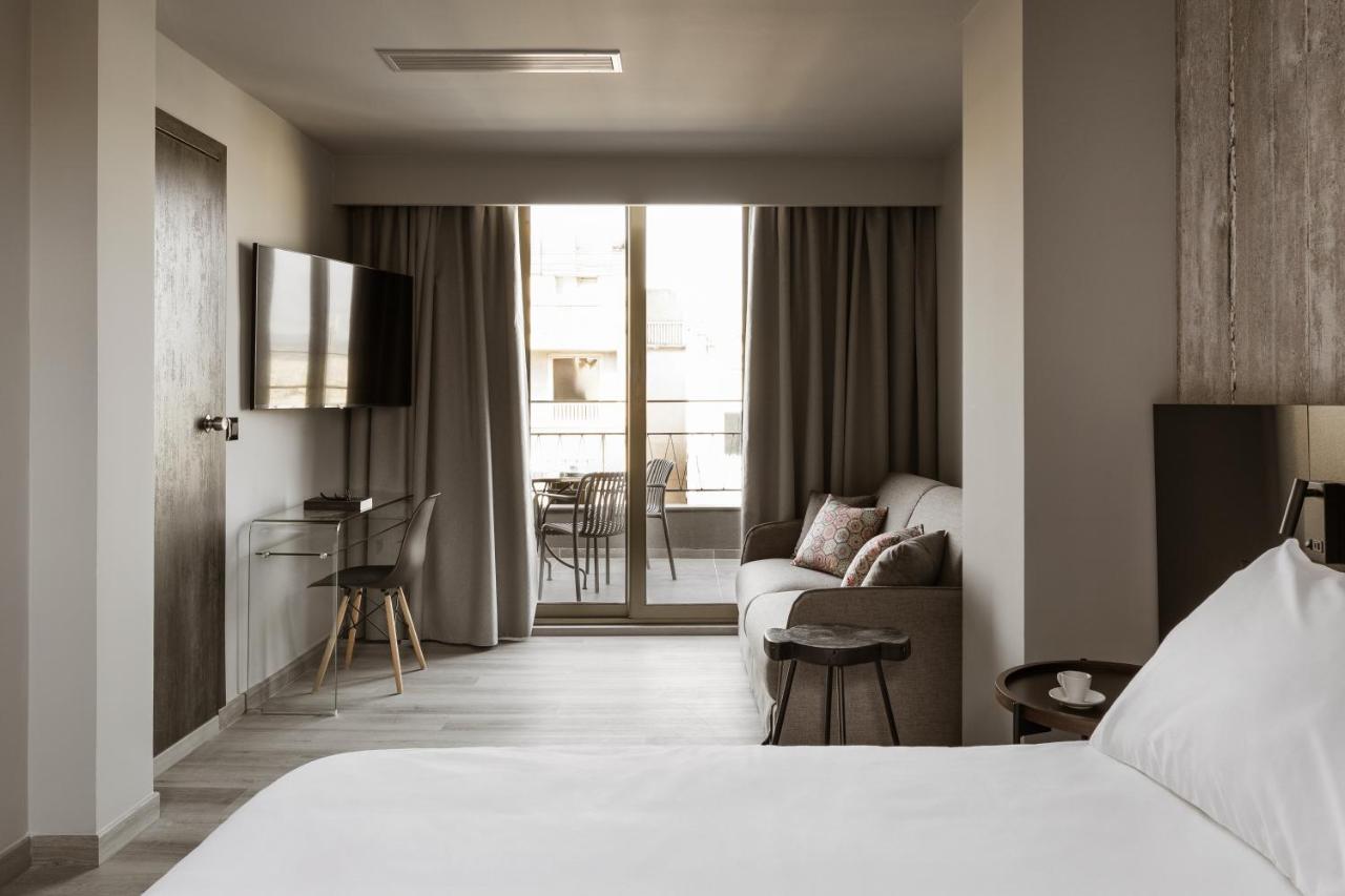 een hotelkamer met een bed en een bank bij Alassia Hotel in Athene