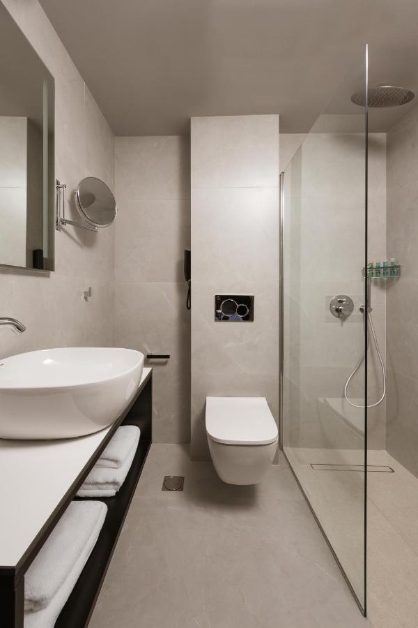 een badkamer met een wastafel, een toilet en een douche bij Alassia Hotel in Athene