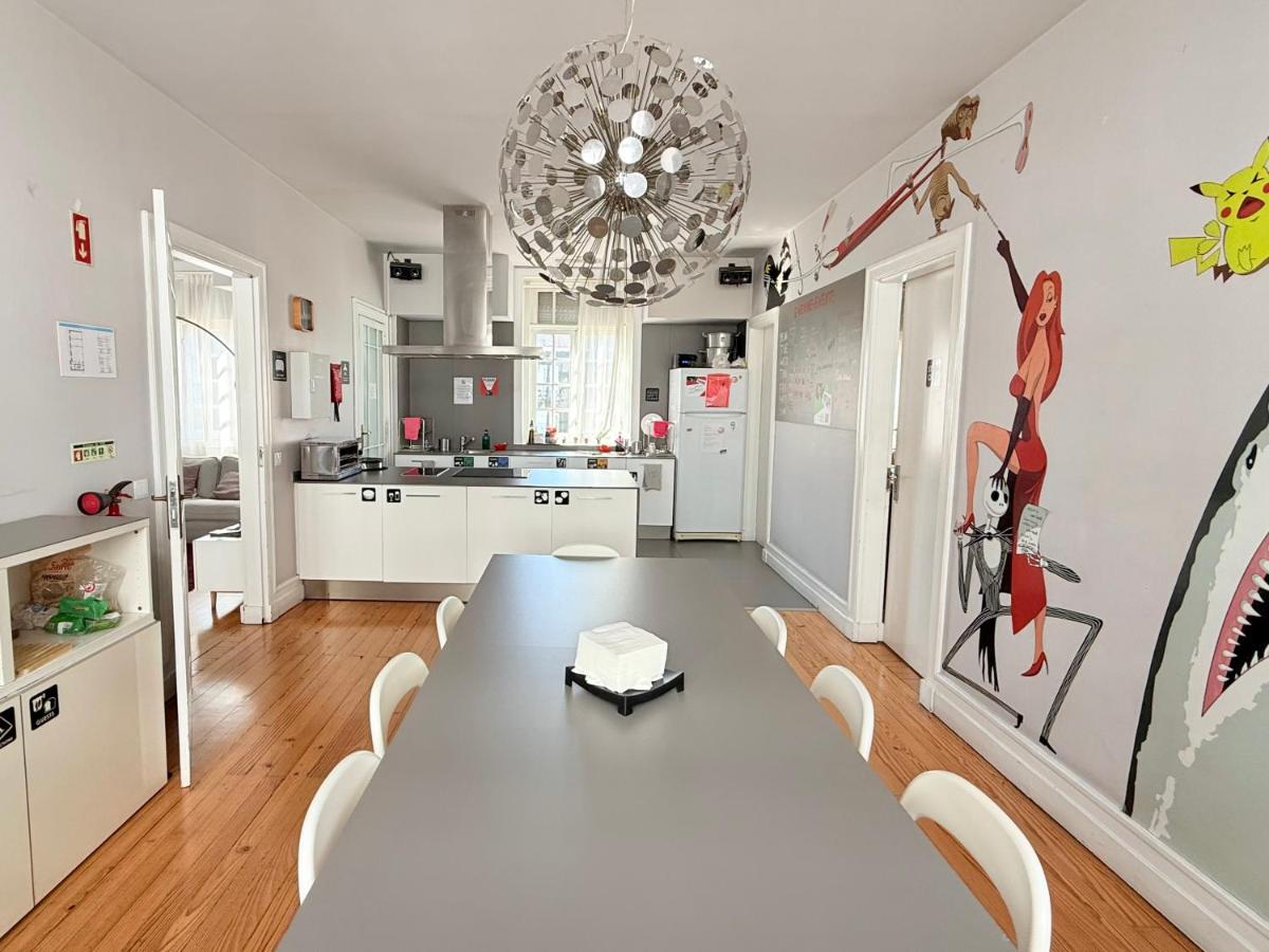 een eetkamer met een tafel en een keuken bij Rivoli Cinema Hostel in Porto