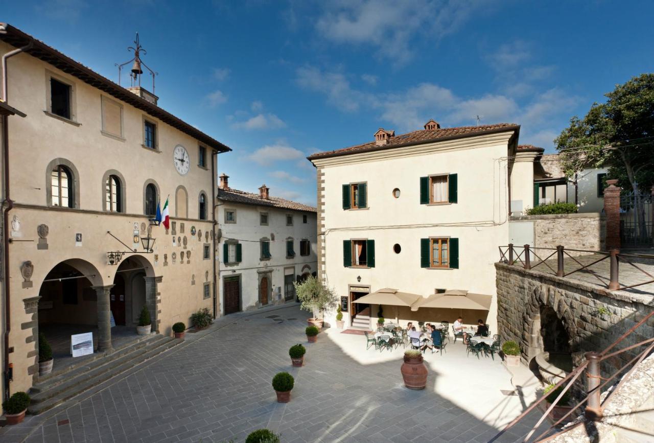 een groep mensen die op een binnenplaats tussen twee gebouwen zit bij Hotel Palazzo San Niccolò & Spa in Radda in Chiant