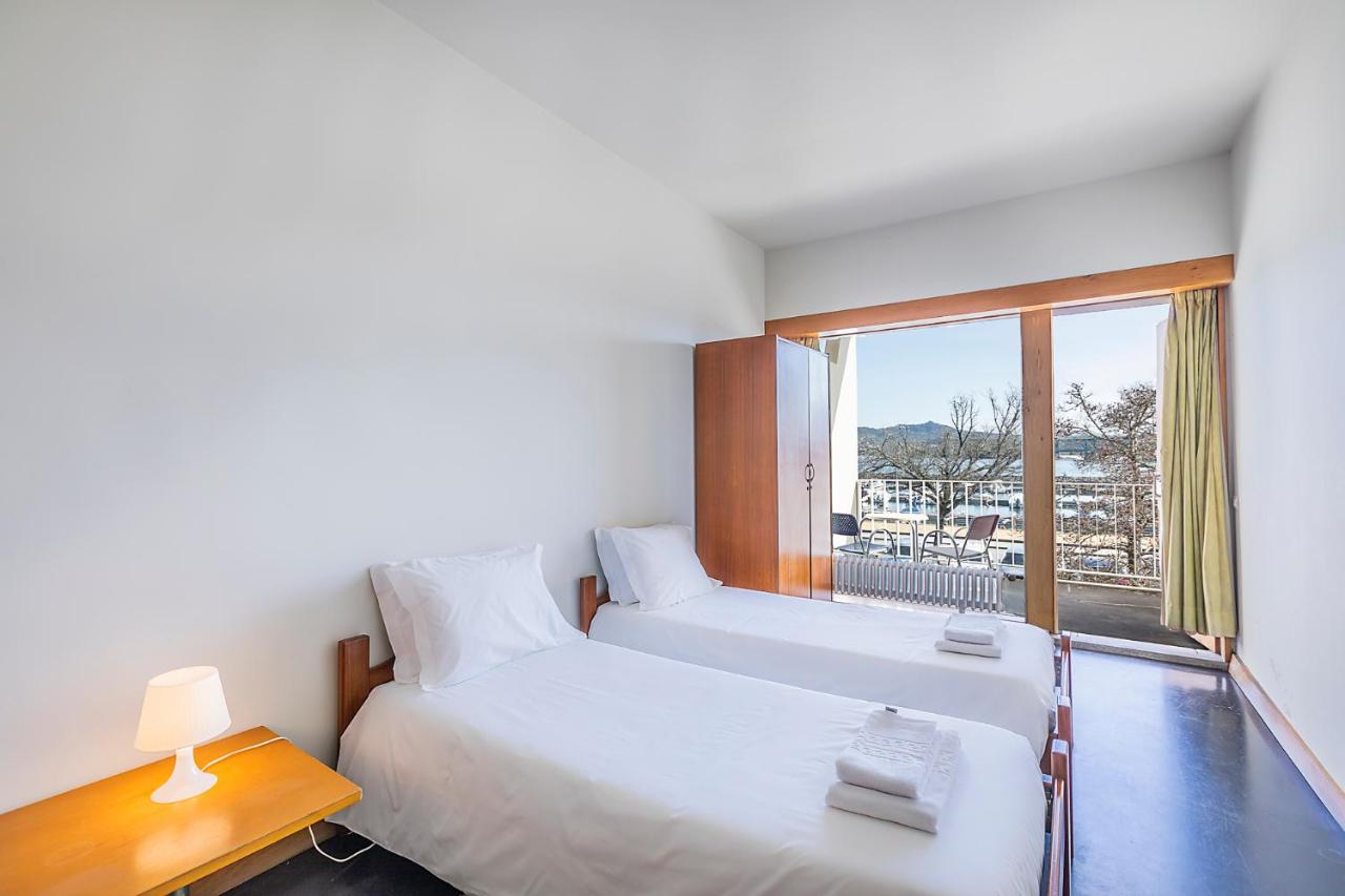 twee bedden in een kamer met een raam bij HI Viana do Castelo - Pousada de Juventude in Viana do Castelo