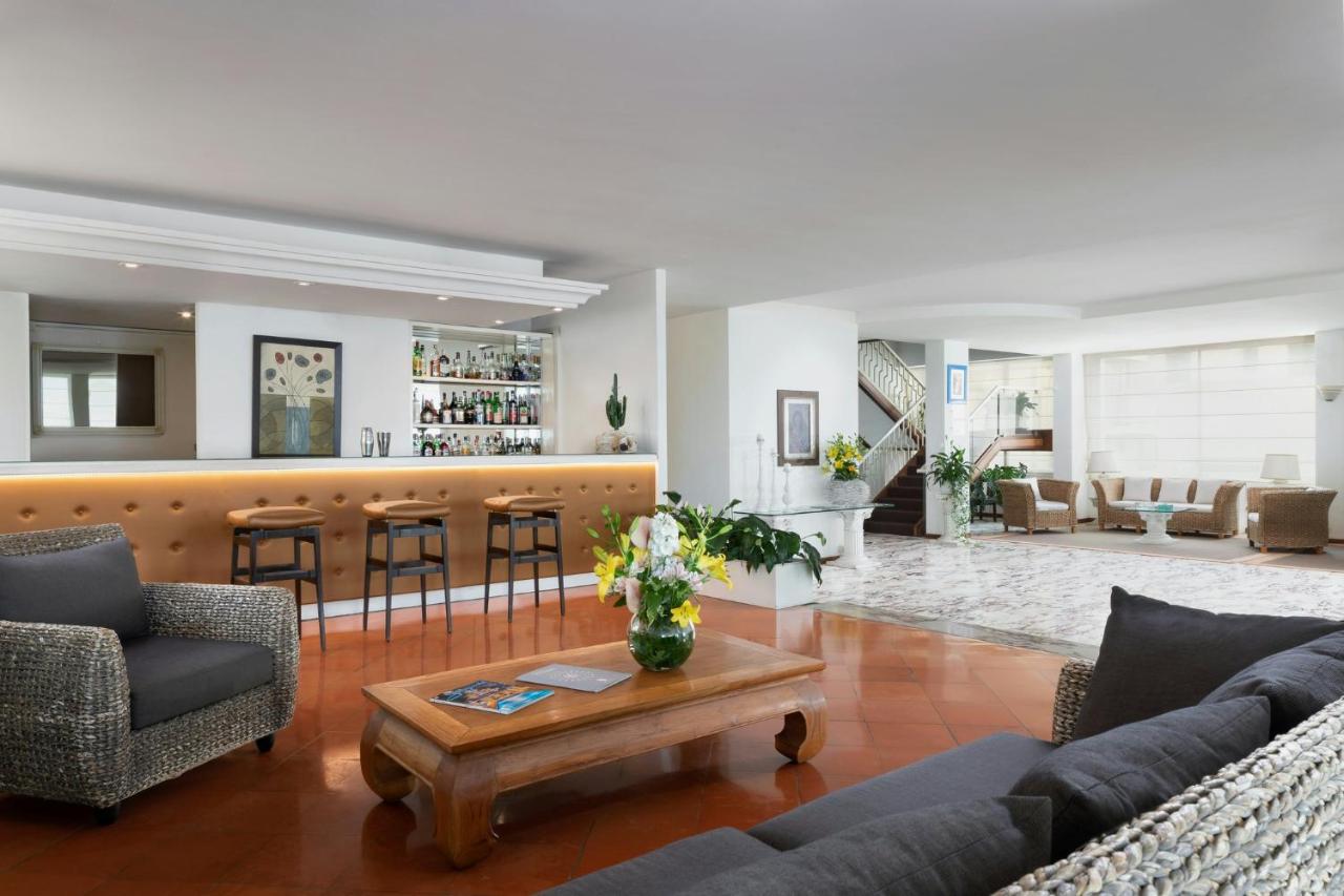 een woonkamer met banken en een bar bij Hotel Sina Astor in Viareggio