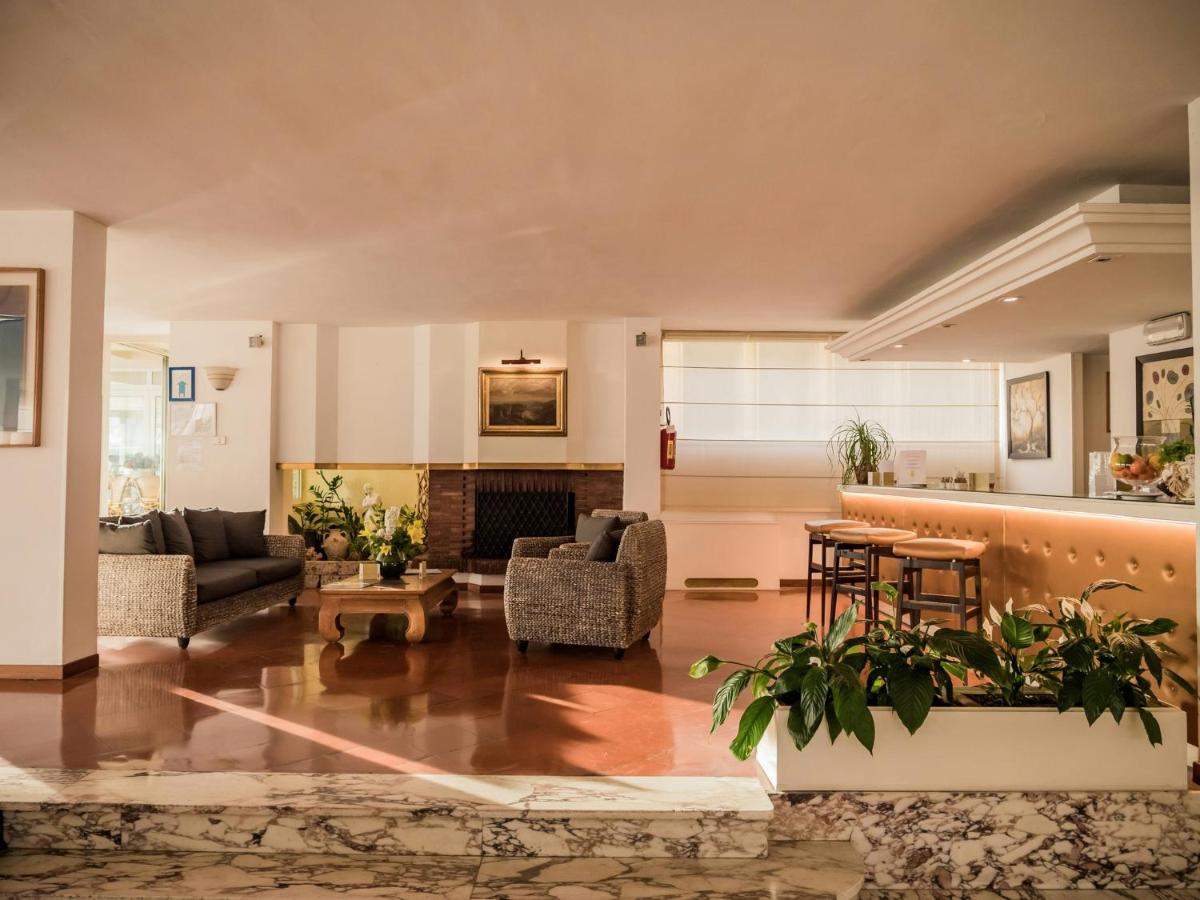 een woonkamer gevuld met meubels en een open haard bij Hotel Sina Astor in Viareggio
