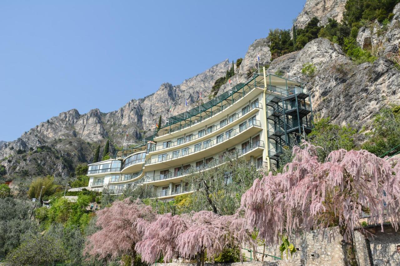 een gebouw tegen de zijkant van een berg bij HOTEL ASTOR in Limone sul Garda