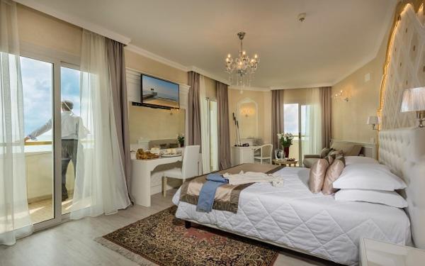 een grote slaapkamer met een groot bed en een balkon bij Luxor e Cairo The Beach Resort in Lido di Jesolo