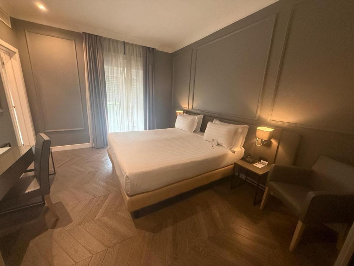een kleine slaapkamer met een bed en een stoel bij Best Western Hotel Astrid in Rome