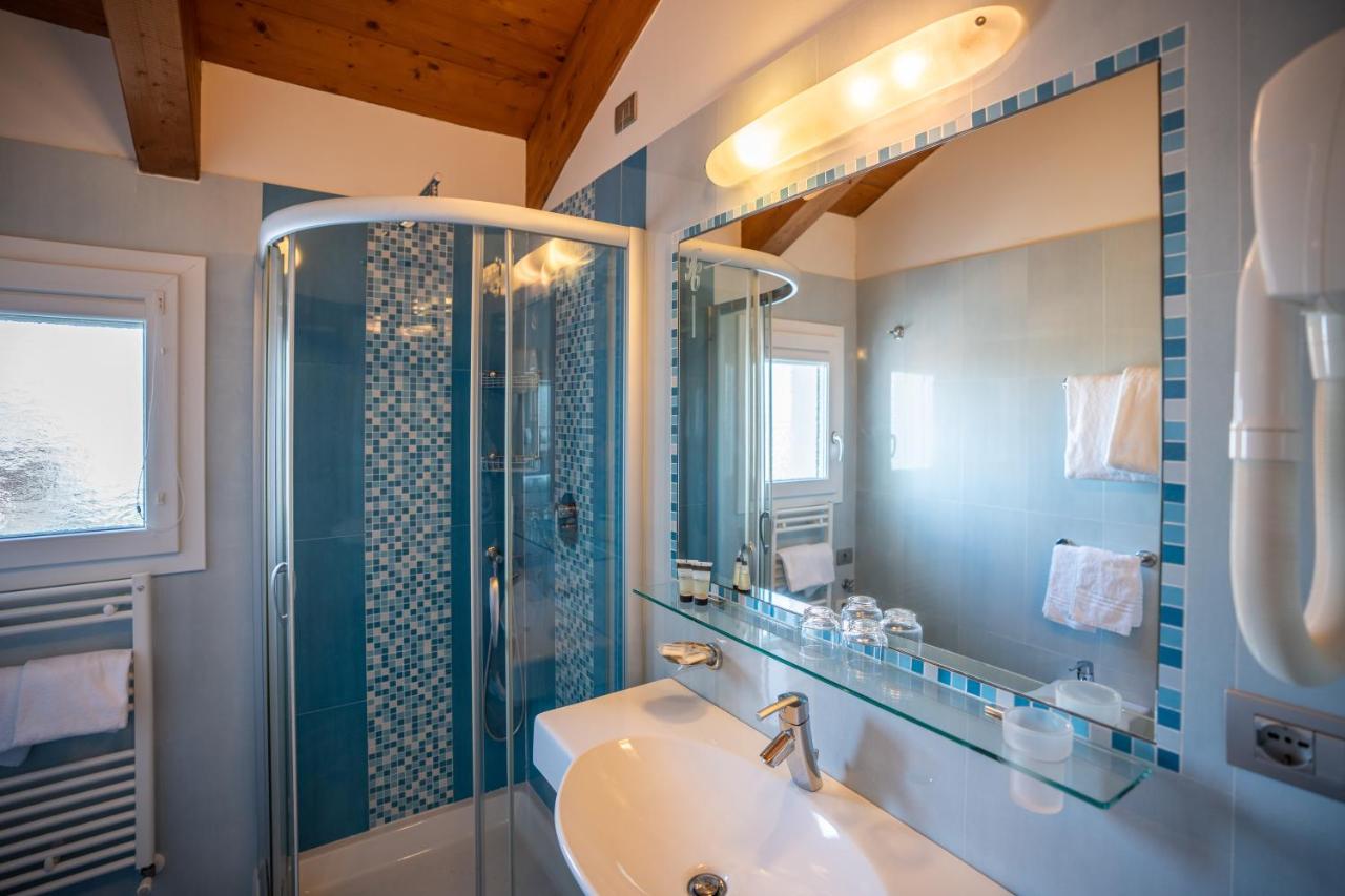 een badkamer met een wastafel, een douche en een bad bij Hotel Coppe Jesolo in Lido di Jesolo
