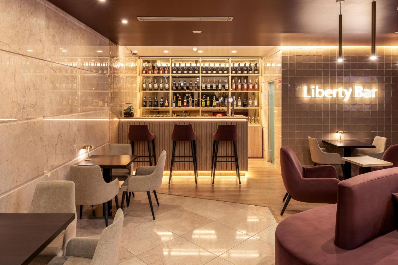 een restaurant met tafels en stoelen en een bar bij America Diamonds Hotel in Lissabon