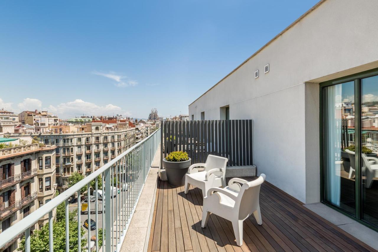 een balkon met witte stoelen en uitzicht op de stad bij Room Mate Carla, Barcelona in Barcelona