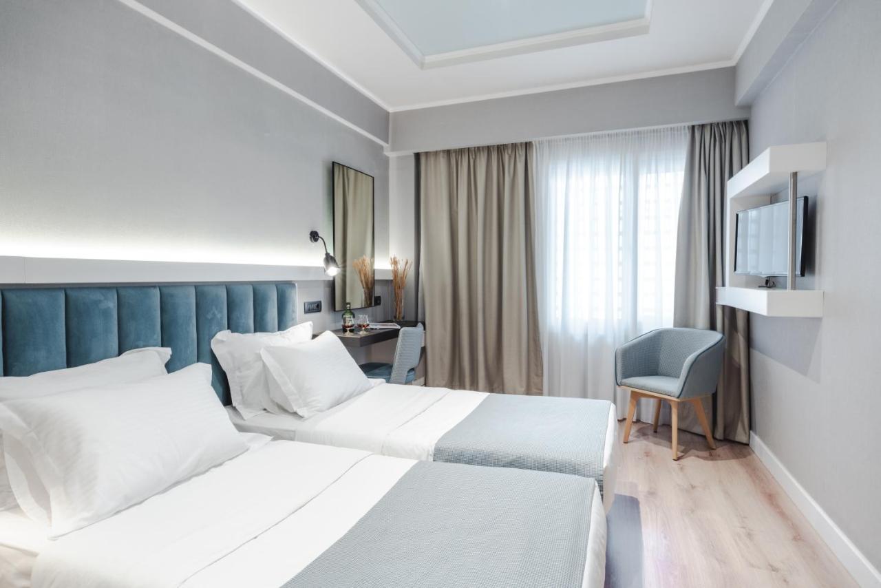een hotelkamer met twee bedden en een televisie bij Athens Cypria Hotel in Athene +146 foto's