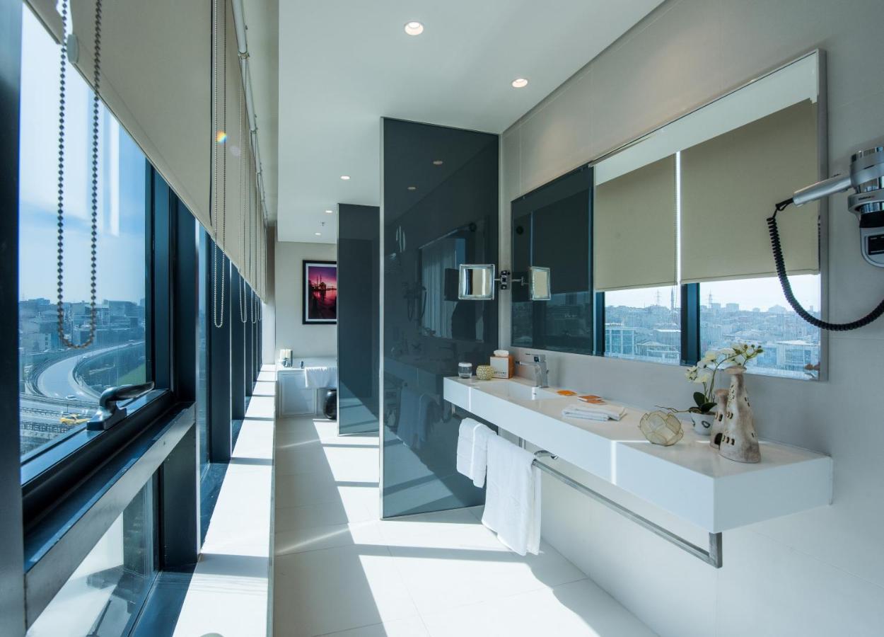 een badkamer met twee wastafels en grote ramen bij Centro Westside by Rotana in Istanbul