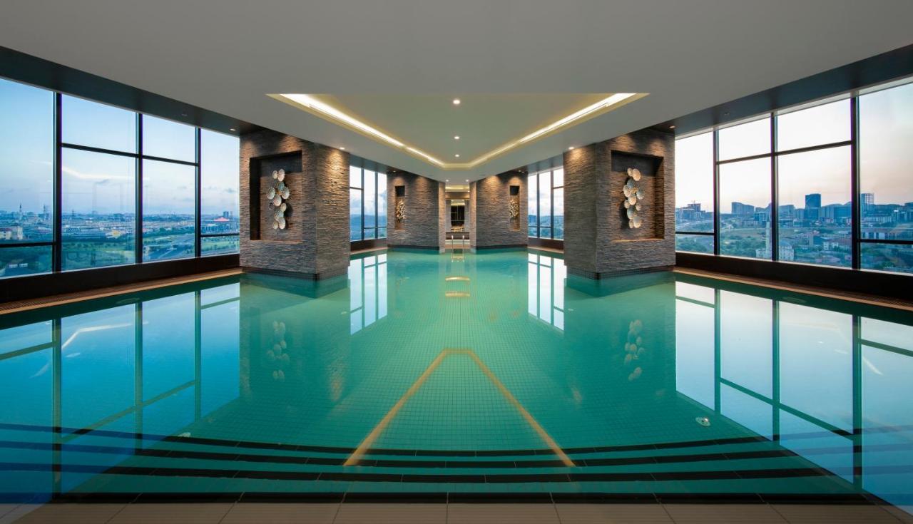 een zwembad in een gebouw met ramen bij Centro Westside by Rotana in Istanbul