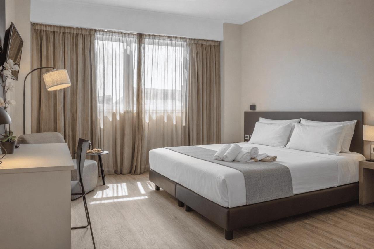 een slaapkamer met een bed en een groot raam bij Hotel Capannelle Roma in Rome