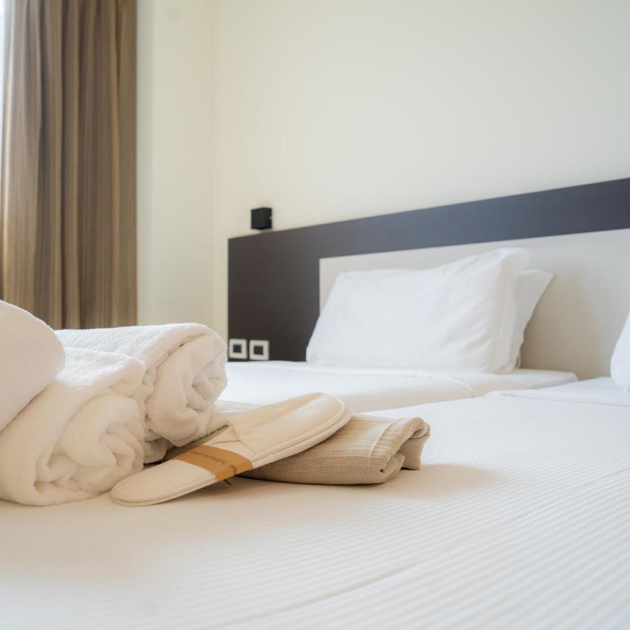 een hotelkamer met een paar schoenen op het bed bij Hotel Capannelle Roma in Rome