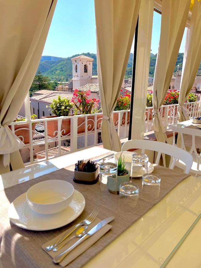 een tafel met borden en bestek op een balkon bij Residenza il Barone in Tropea