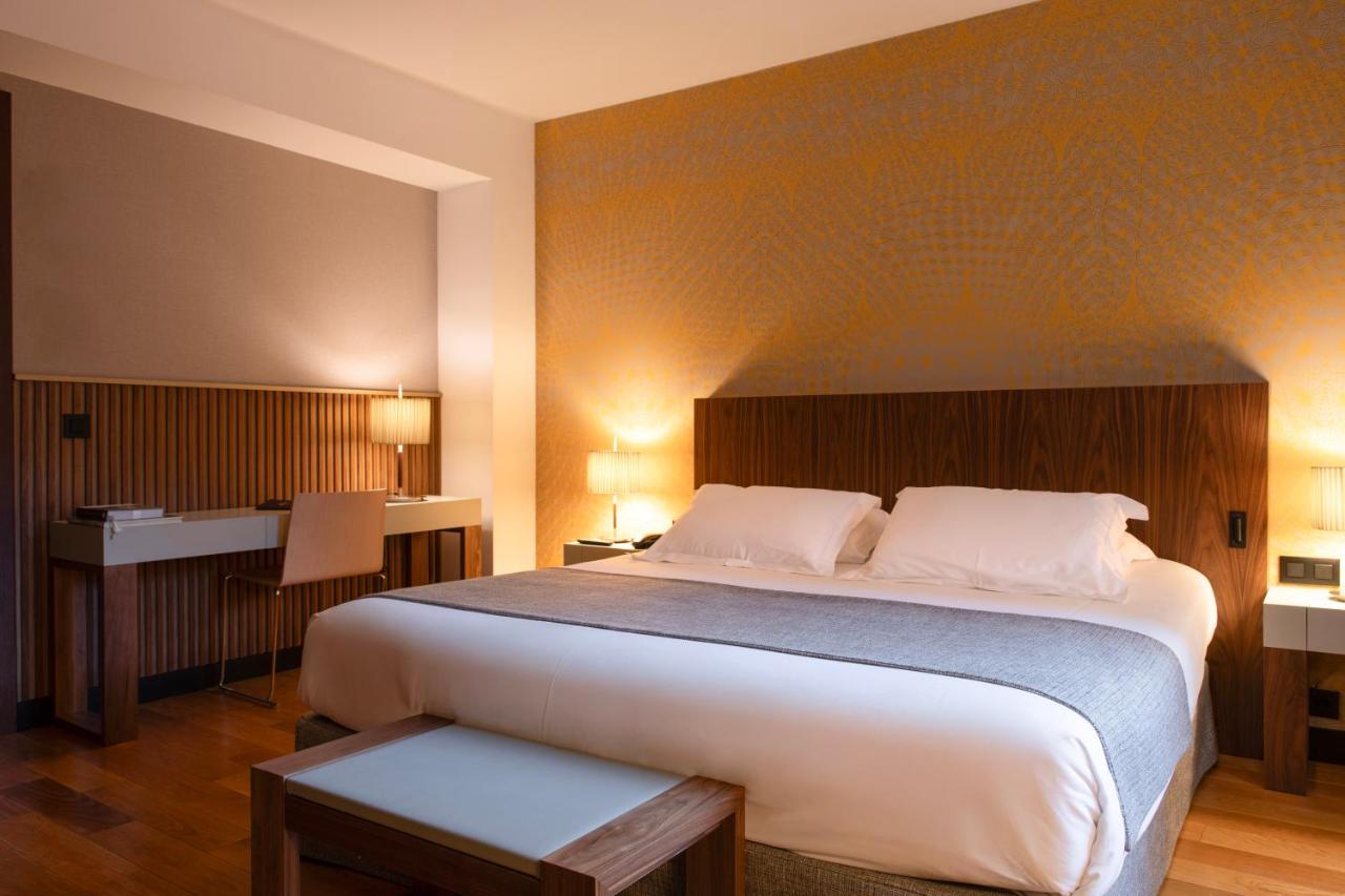 een slaapkamer met een groot bed en een bureau bij Hotel Villa Emilia in Barcelona