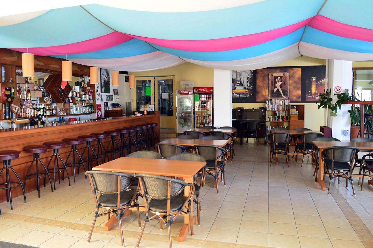 een restaurant met tafels en stoelen en een bar bij Alexandros Hotel in Sissi