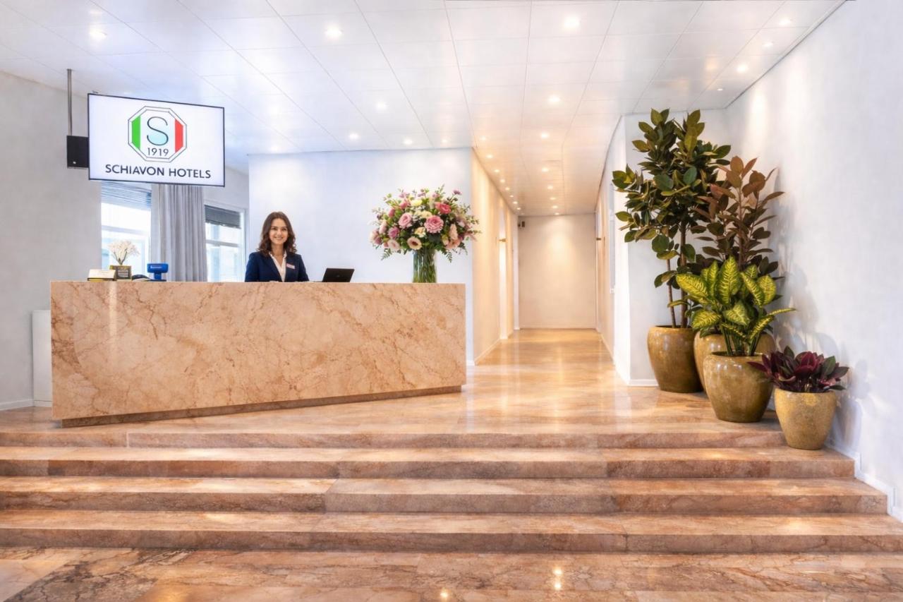 een vrouw die aan een balie in een lobby staat bij Hotel Pex Mantova in Mantova