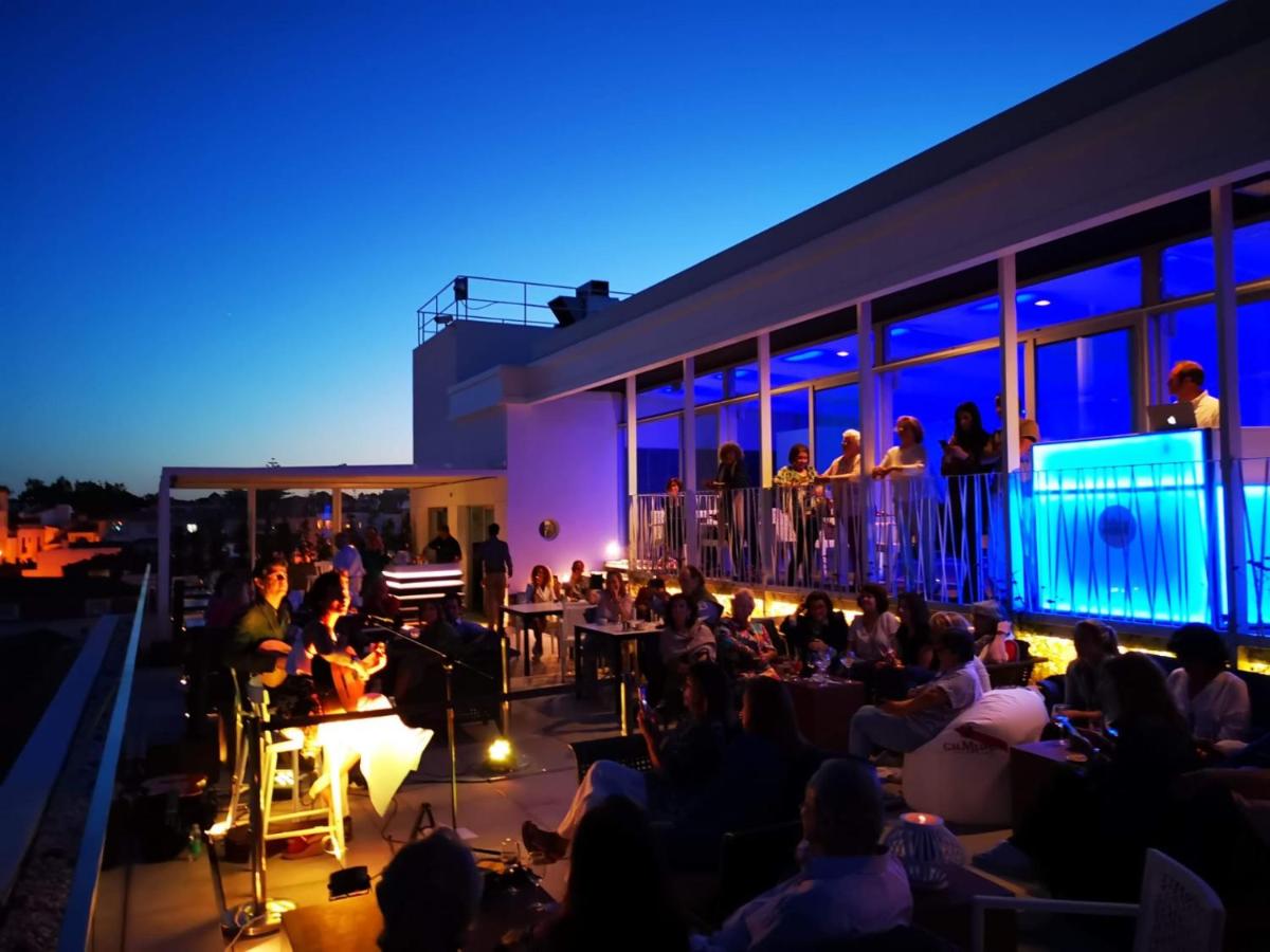 een groep mensen die 's nachts op een balkon zit bij Hotel Baia in Cascais +107 foto's