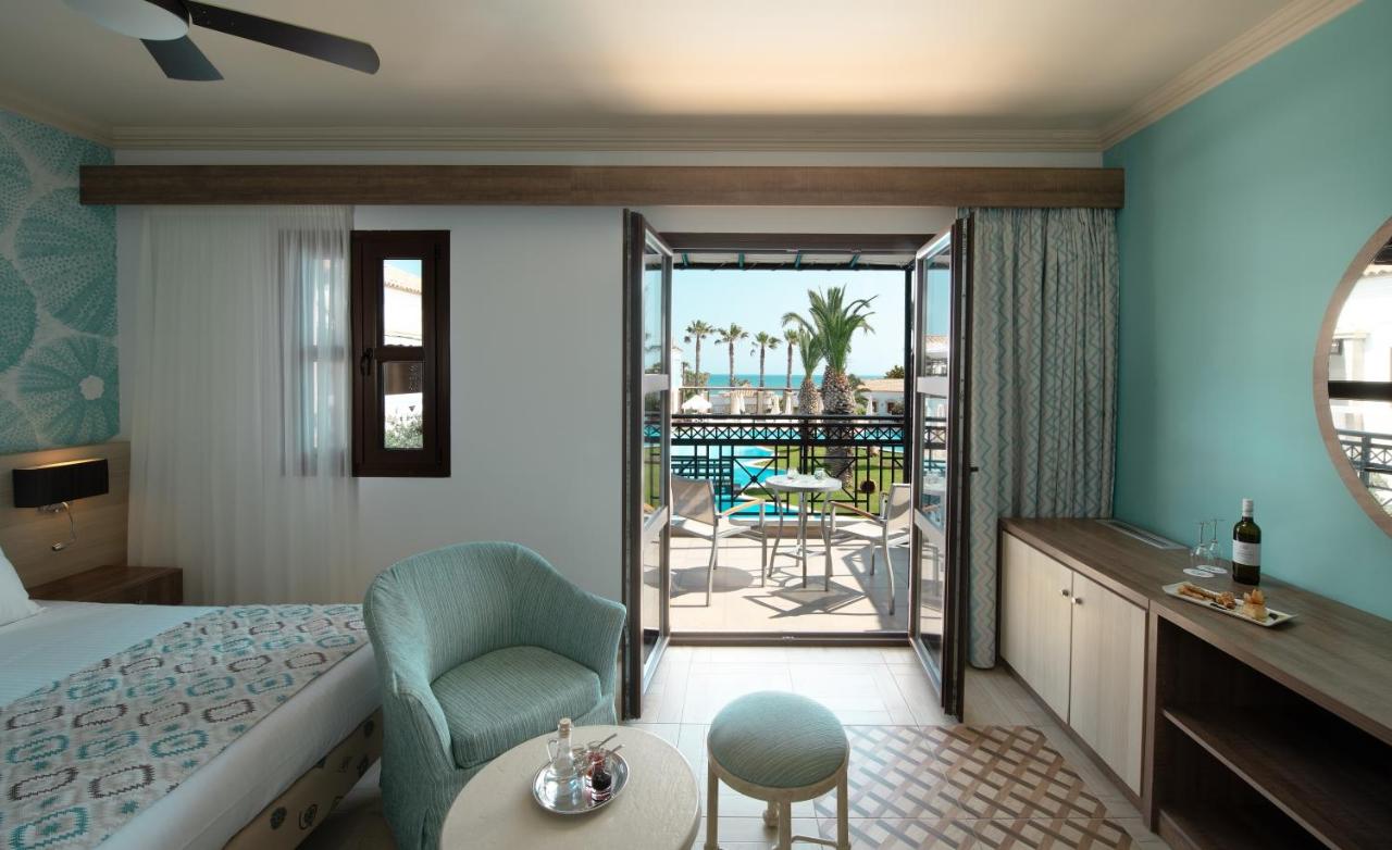 een hotelkamer met een bed en een balkon bij Mitsis Royal Mare in Chersonissos +124 foto's