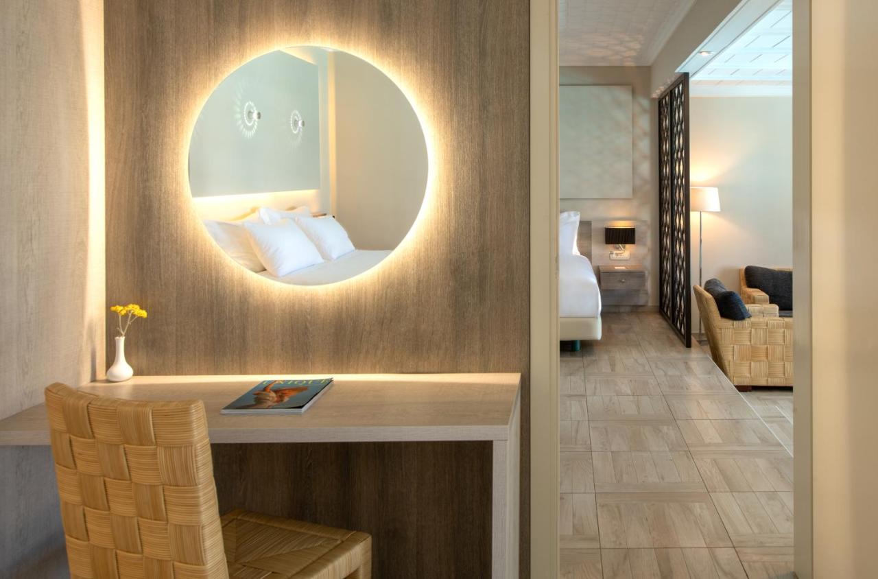 een hotelkamer met een bed en een spiegel bij Mitsis Royal Mare in Chersonissos