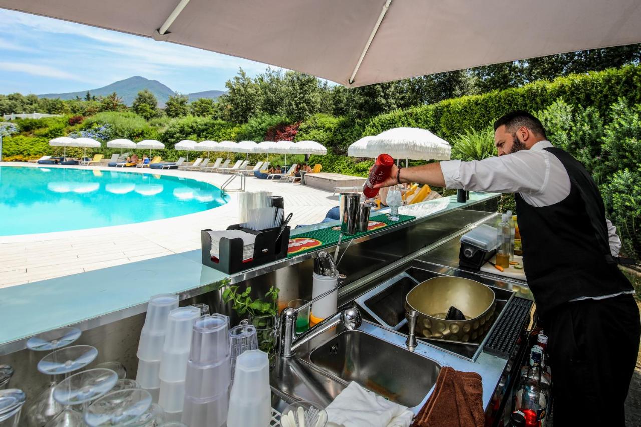 Een man bereidt eten in een keuken naast een zwembad. bij Il San Cristoforo in Ercolano