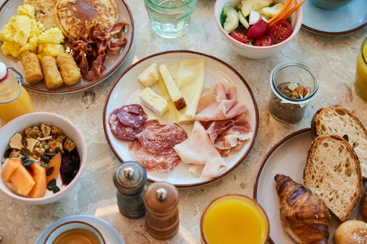 een tafel vol met borden met ontbijtproducten bij The Social Hub Florence Lavagnini in Florence