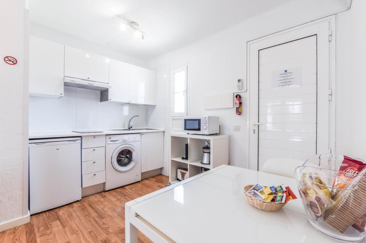 een keuken met witte kasten en een witte tafel bij Villas New Lanzasuites in Playa Blanca