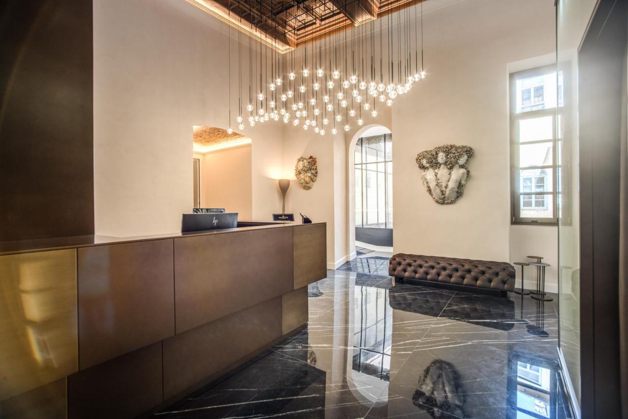 een lobby met een receptiebalie en een kroonluchter bij Martius Private Suites Hotel in Rome