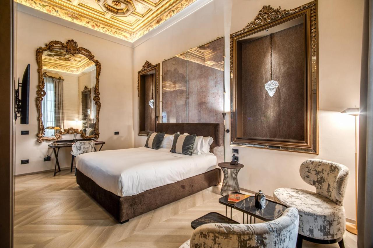 een hotelkamer met een bed en een stoel bij Martius Private Suites Hotel in Rome