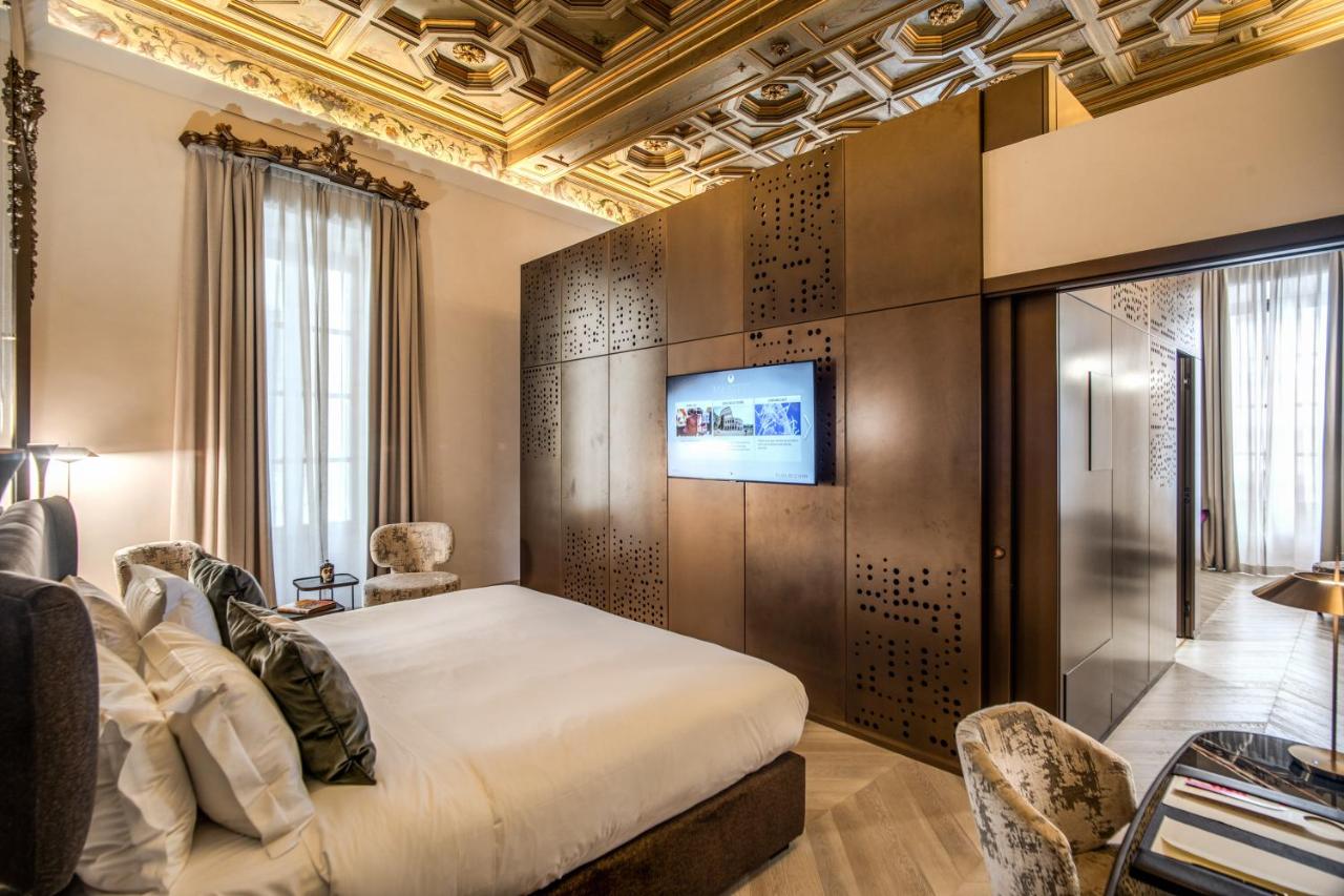 een slaapkamer met een bed en een tv aan de muur bij Martius Private Suites Hotel in Rome