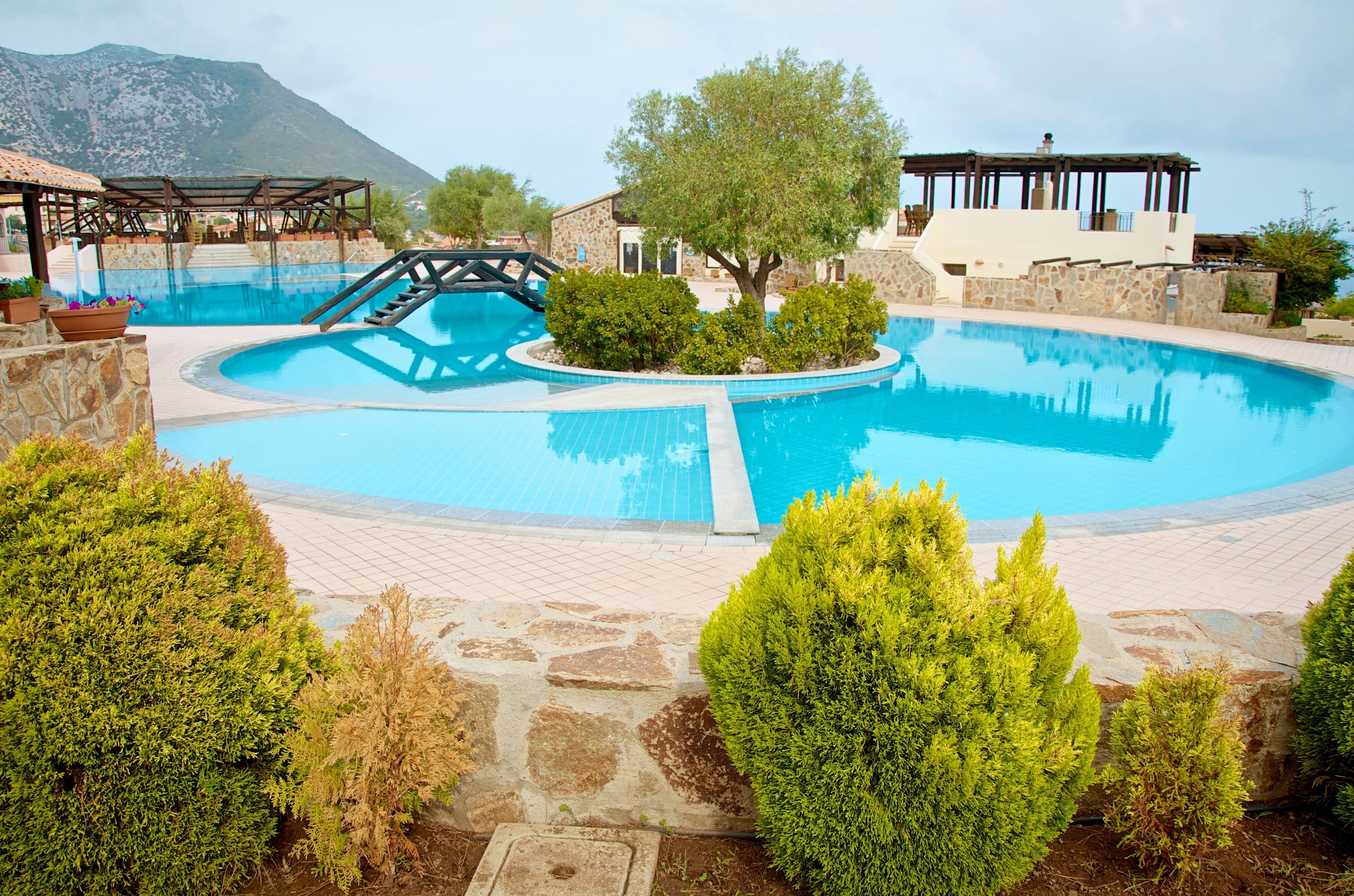 Zwembad omringd door palmbomen — Club Esse Cala Gonone