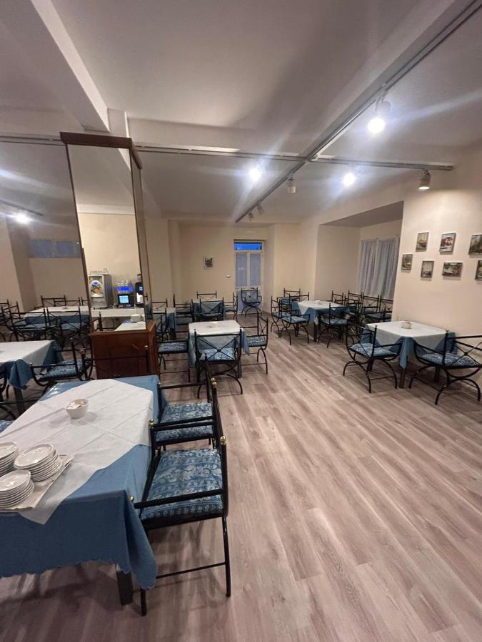 een eetkamer met tafels en stoelen en tafelzoeker bij Hotel Bellevue in Genua