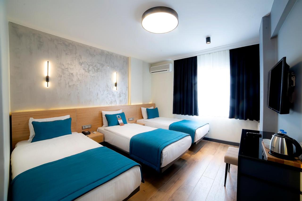 een hotelkamer met twee bedden en een televisie bij Barin Hotel in Istanbul