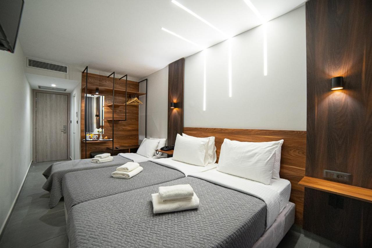 Twee bedden in een hotelkamer met handdoeken erop. bij Argo Hotel Piraeus in Piraeus