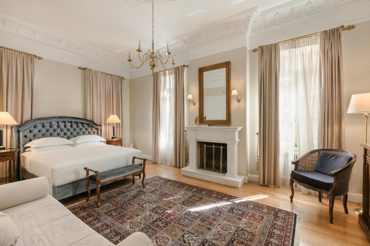 een slaapkamer met een bed en een open haard bij Noble Suites in Athene