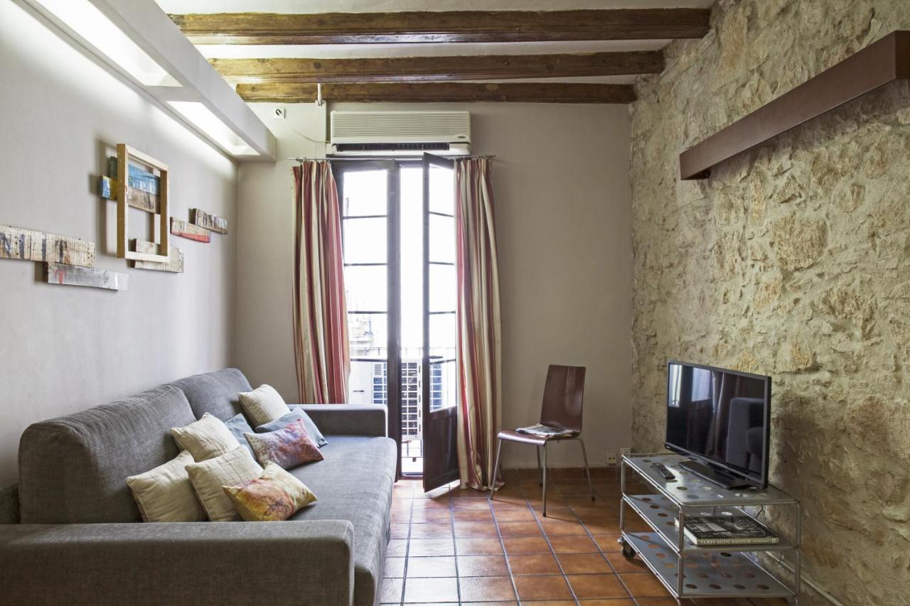 een woonkamer met een bank en een tv bij AinB Las Ramblas-Guardia Apartments in Barcelona
