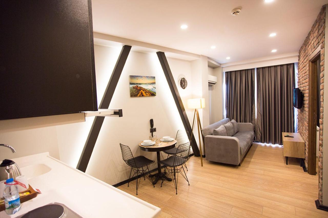 een keuken en woonkamer met een tafel en een bank bij Long Stay İstanbul Residence in Istanbul