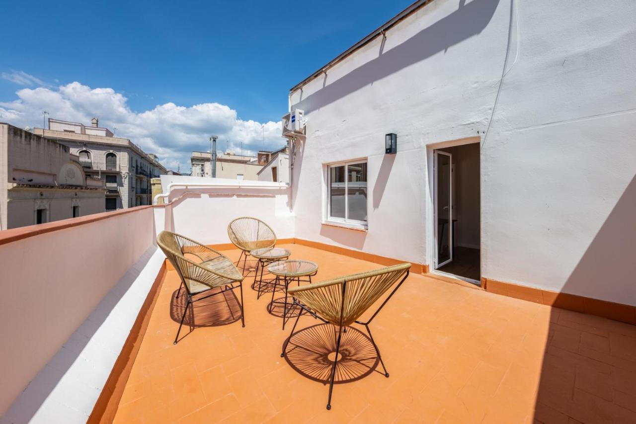 een balkon met stoelen en tafels op een gebouw bij AinB Barcelona Sants Apartments in Barcelona