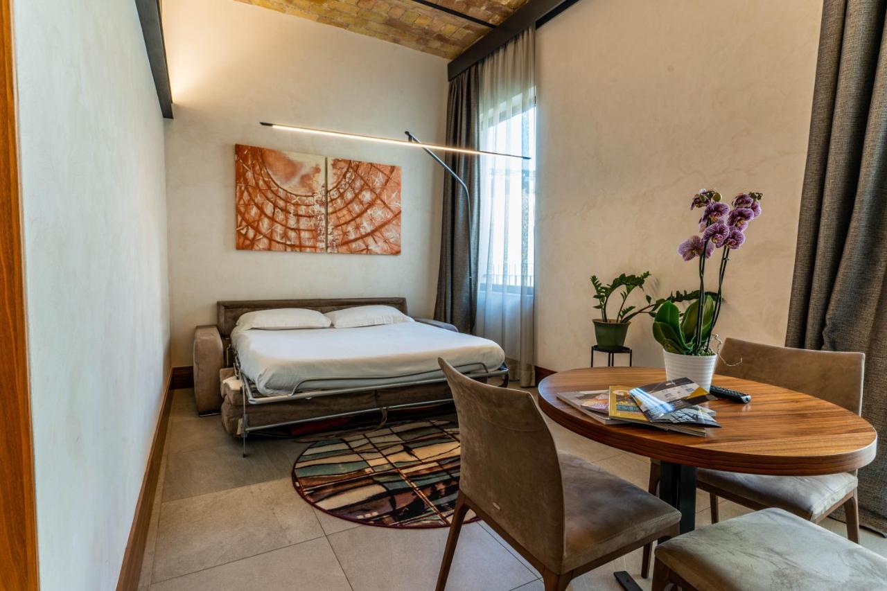 een slaapkamer met een bed, een tafel en stoelen bij Gasometer Urban Suites in Rome